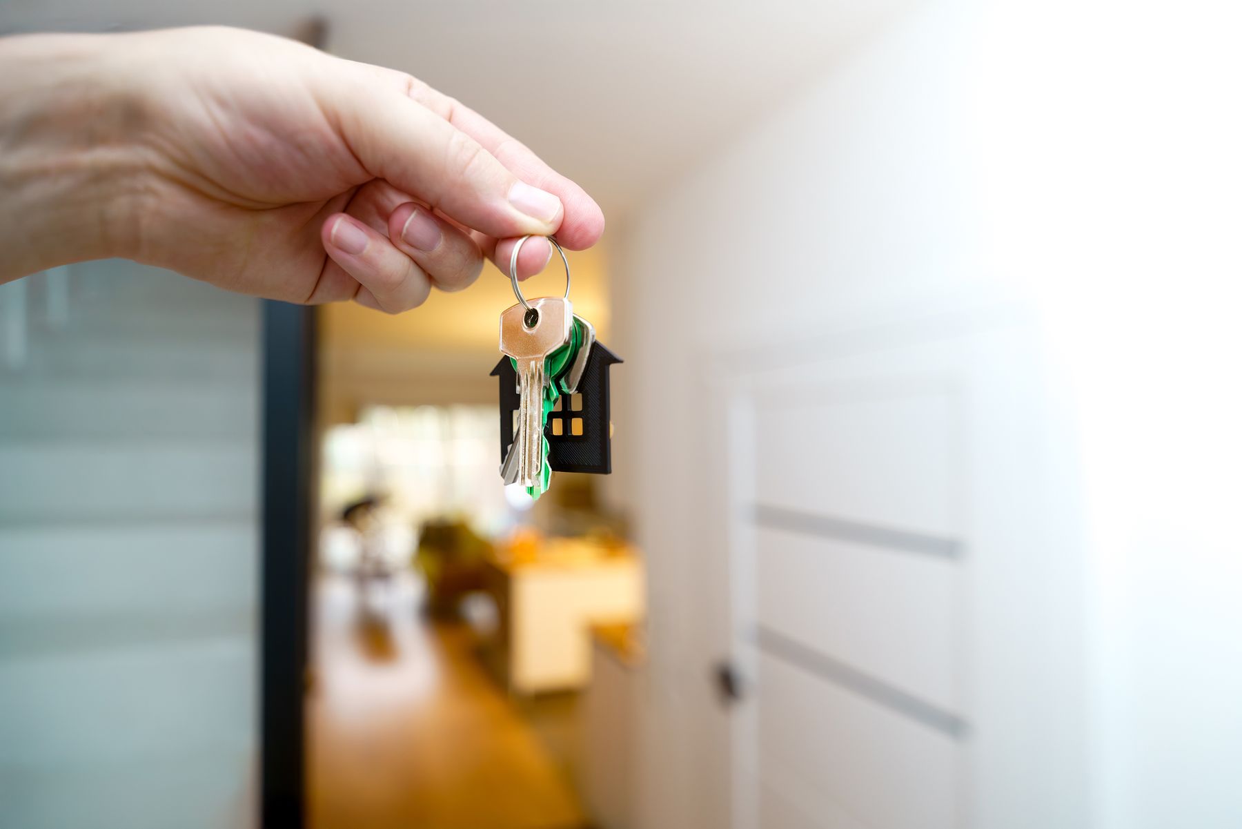 Llaves de vivienda sostenidas dentro de un apartamento nuevo