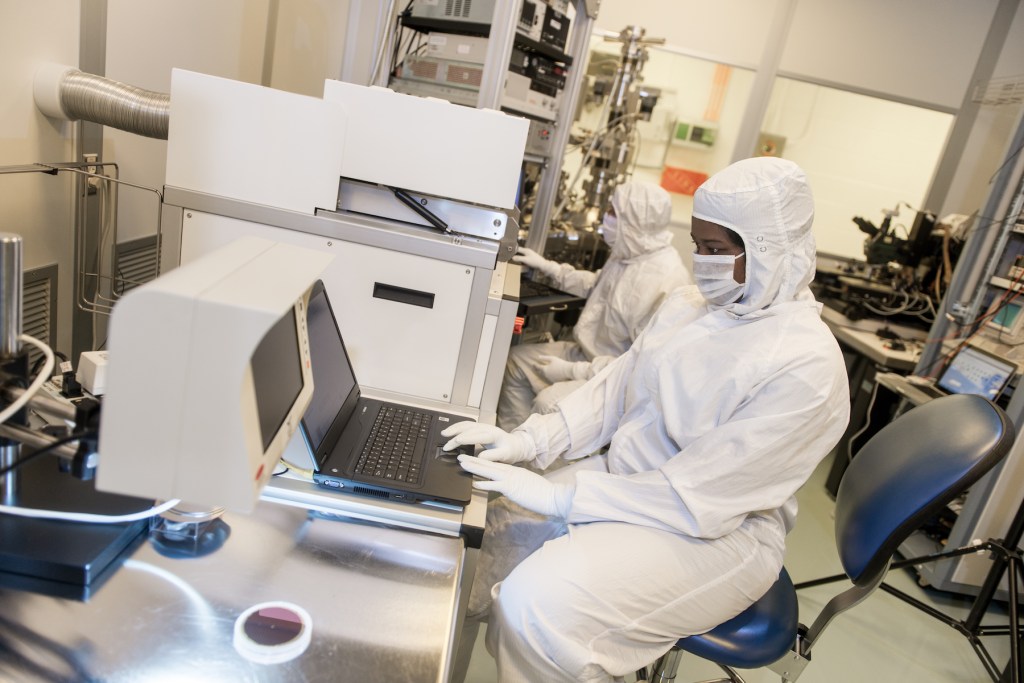 NASA semiconductor cleanroom technician working near fabrication equipment